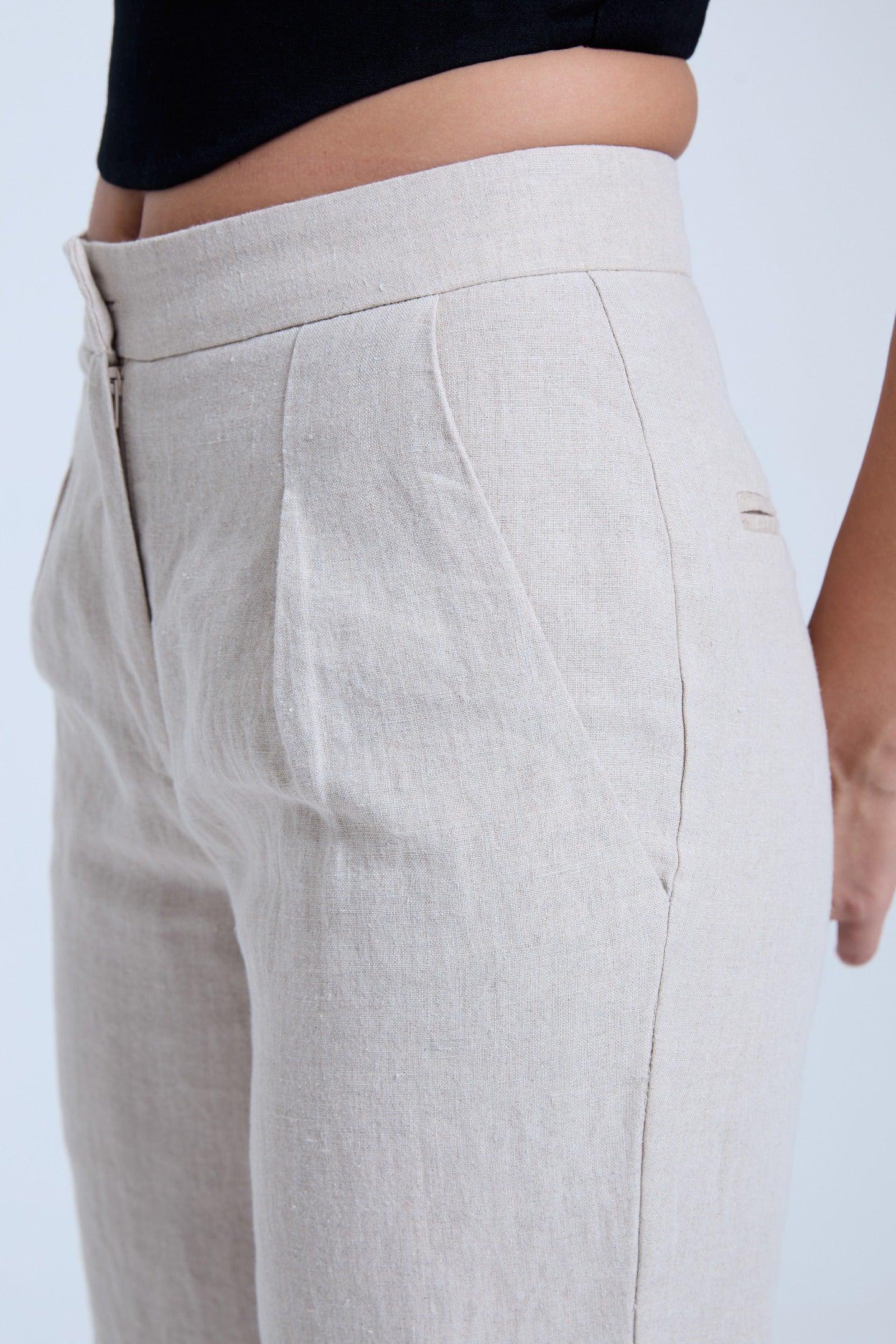 Closeup of beige linen high-waisted women’s pants with side pocket detail